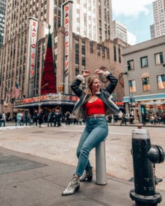 girl standing across the street from Radio City