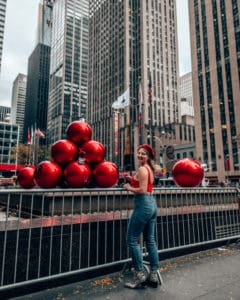 girls tanning in front of red giant ornaments