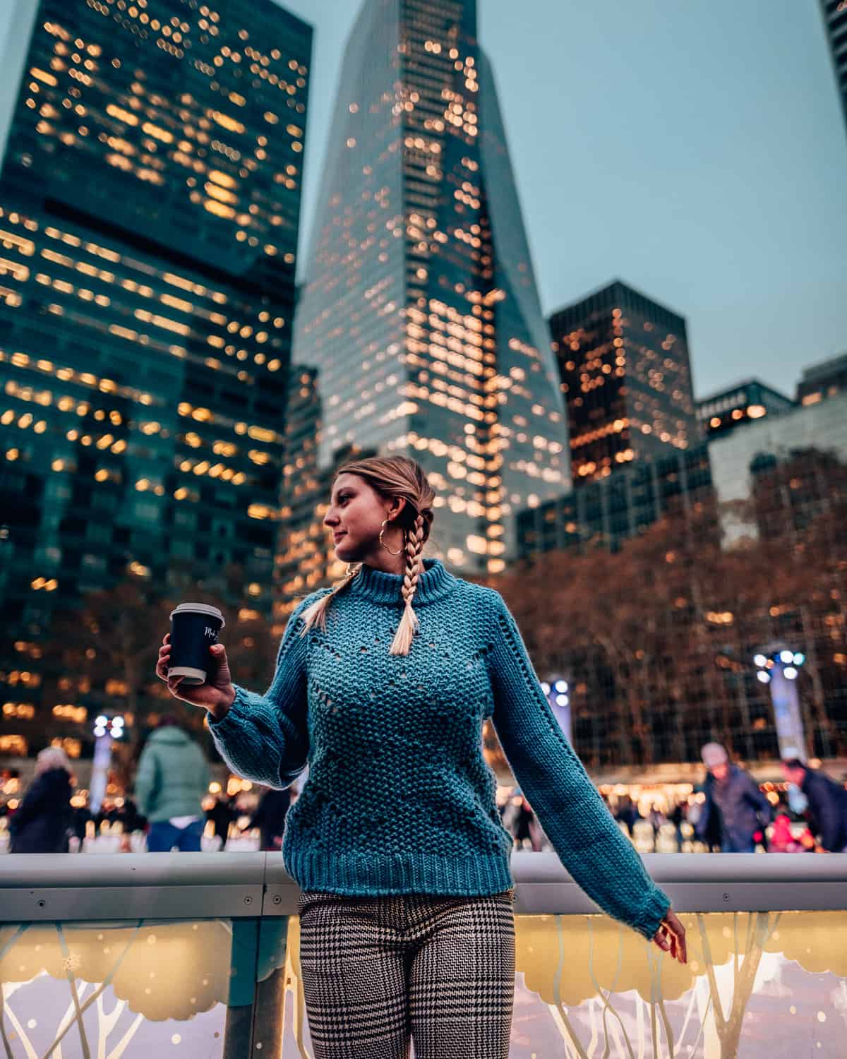 girl standing in front of a skating rink and sky scrapers