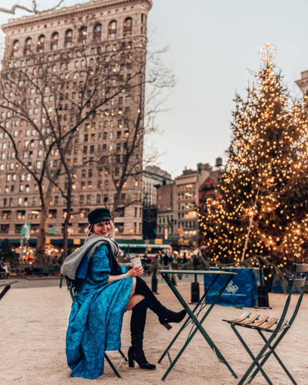 girl sitting in front of tree and building