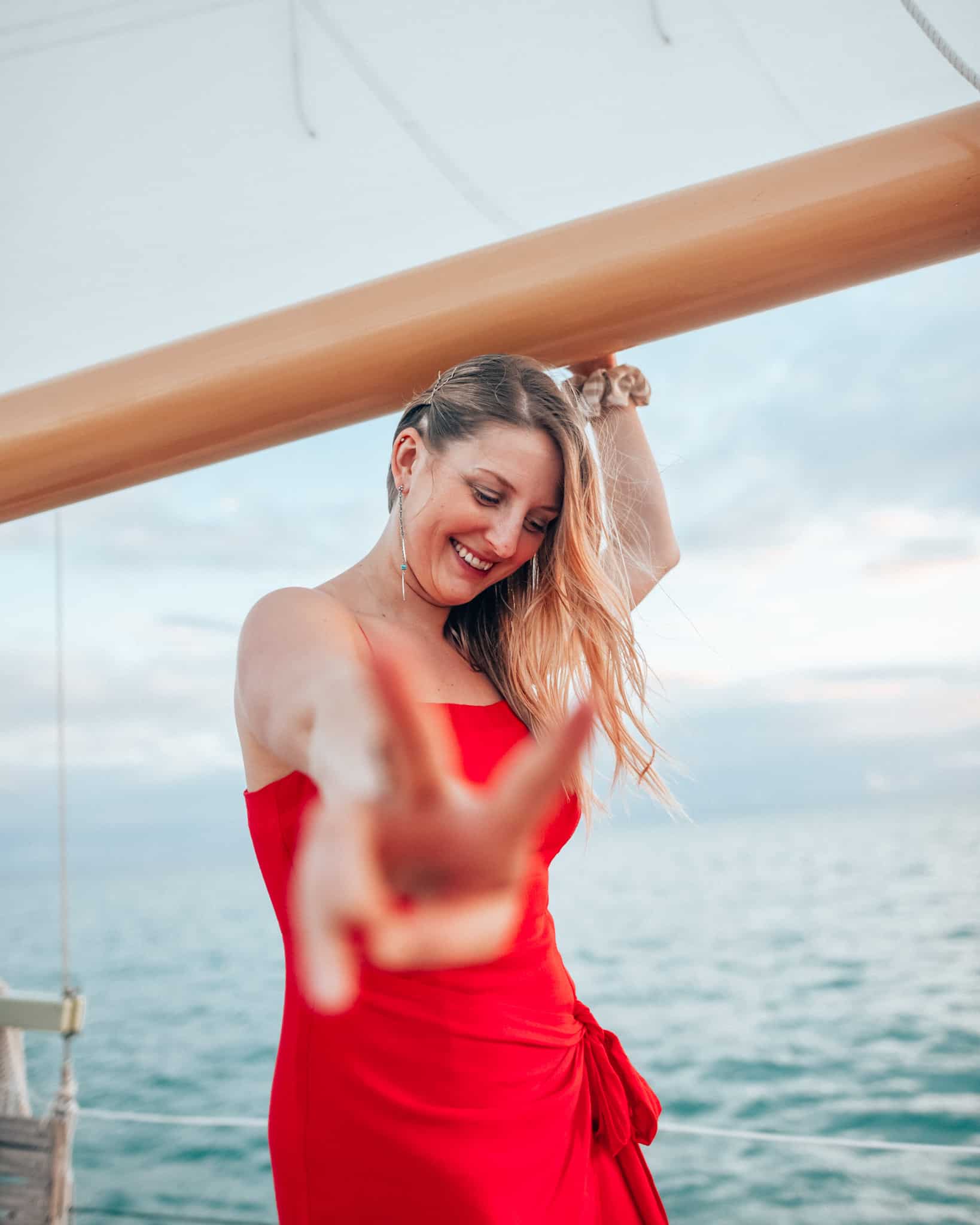 girl holding a sail making a peace sign