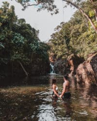 Couple se tenant dans un lagon dans la forêt tropicale