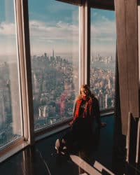 chica sentada en el último piso del edificio con vistas