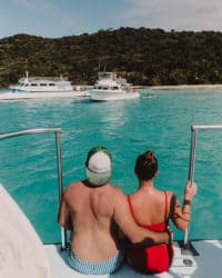 pareja sentada en el borde del catamarán