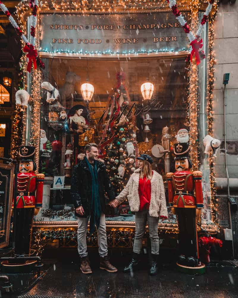 couple standing holding hands in front of a window