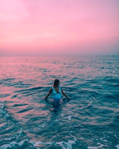 girl in water, Pink sunset over ocean
