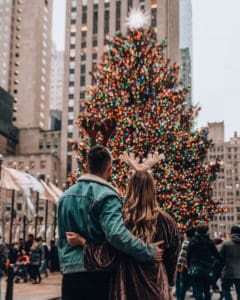 couple wearing antler in front of a tree