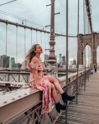 chica sentada en la cornisa del puente de Brooklyn