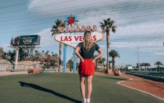 standing facing "welcome to Las Vegas" sign